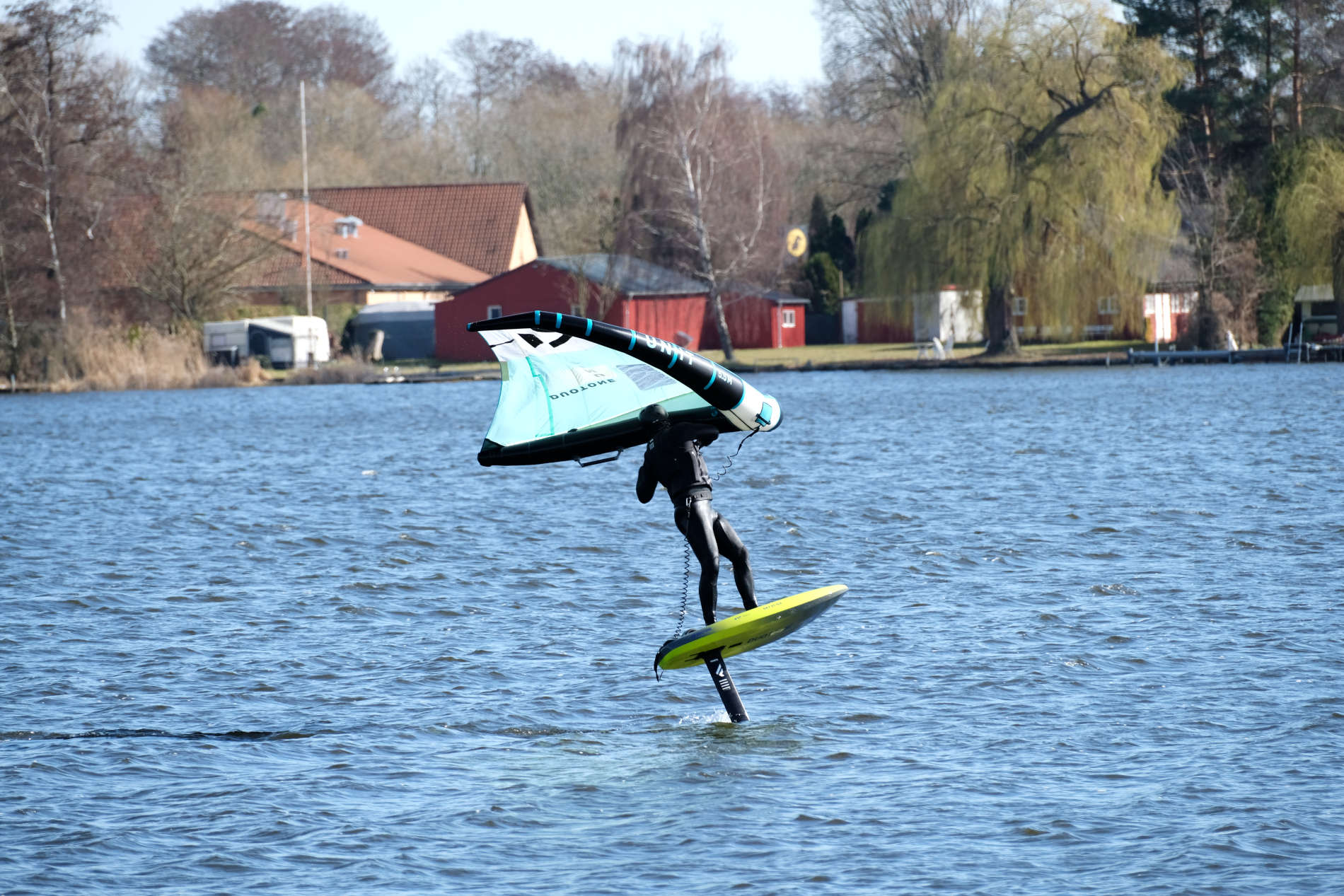 Wingfoiler beim Einleiten einer Wende auf einem Foilboard