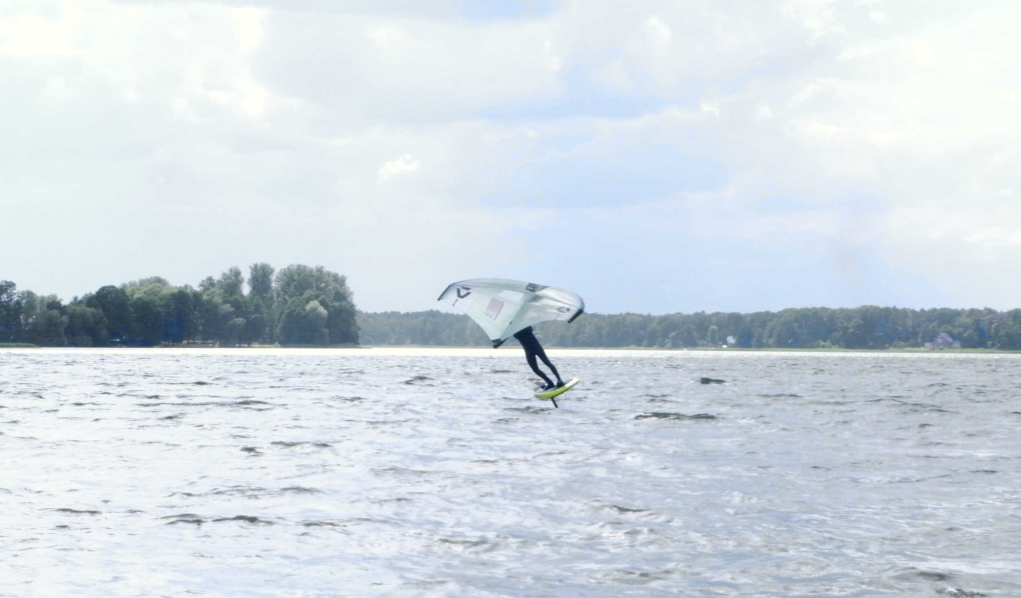 Wingfoiler bei einer Halse auf einem See - Coverfoto zum Blogbeitrag zum leichteren Lernen der Wingfoil-Halse bei maavr