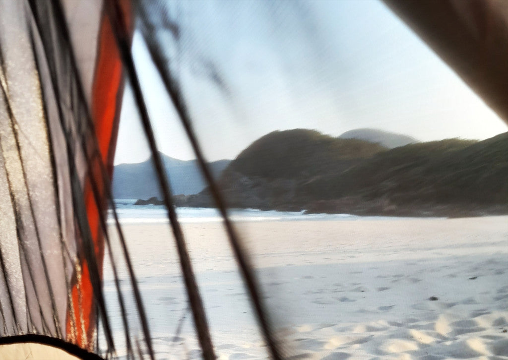 Blick aus einem Zelt an einem einsamen Strand in Asien - Lifestylefoto für maavr