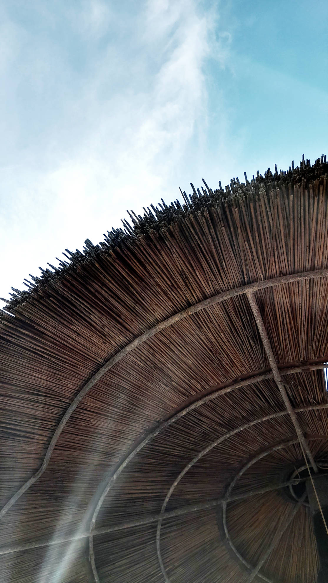 POV Closeup eines Sonnenschirms aus Naturmaterial am Strand