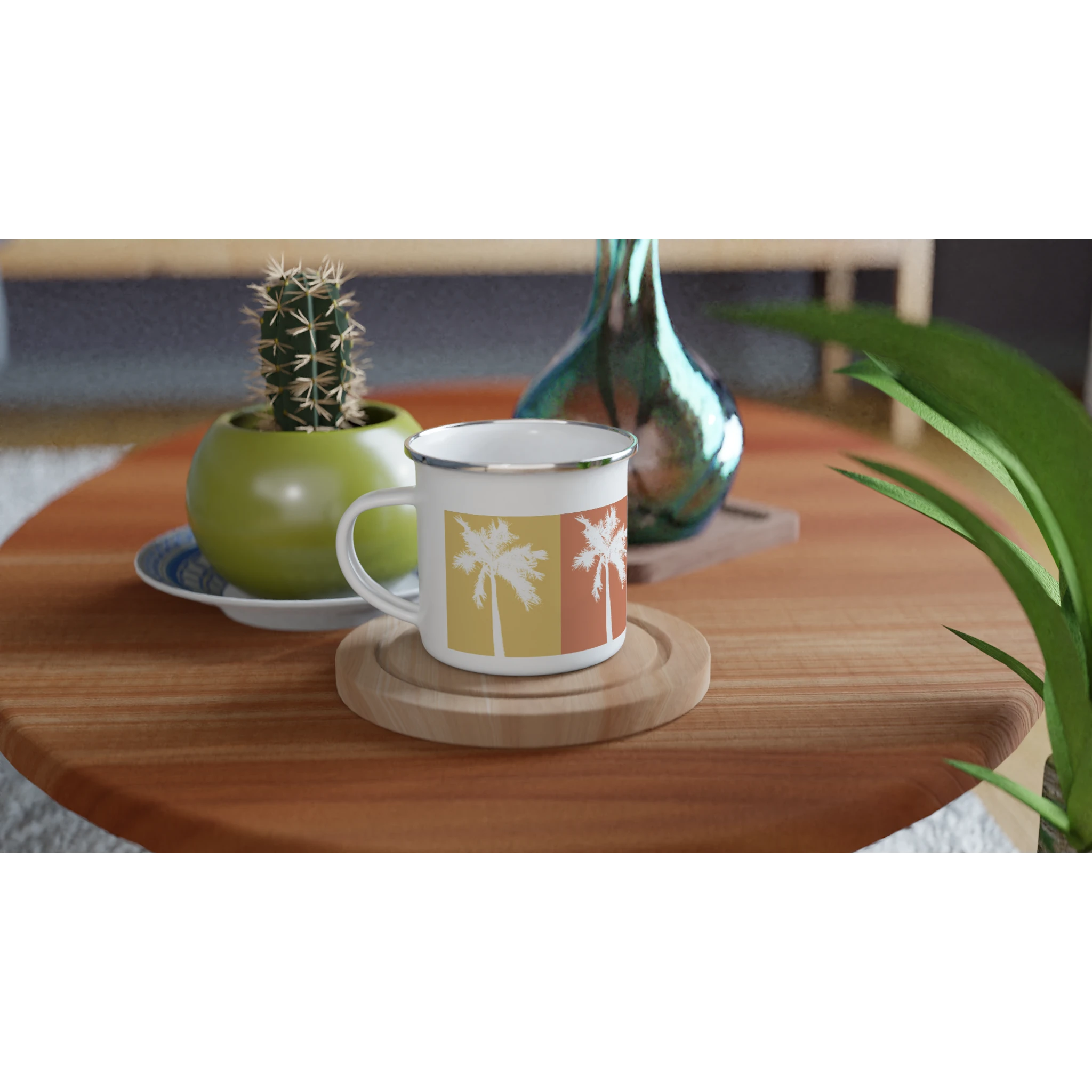 Weiße Emaille-Tasse mit Retro-Palmenmotiv in warmen Sommerfarben  auf einem Holztisch mit Kaktus und Vase