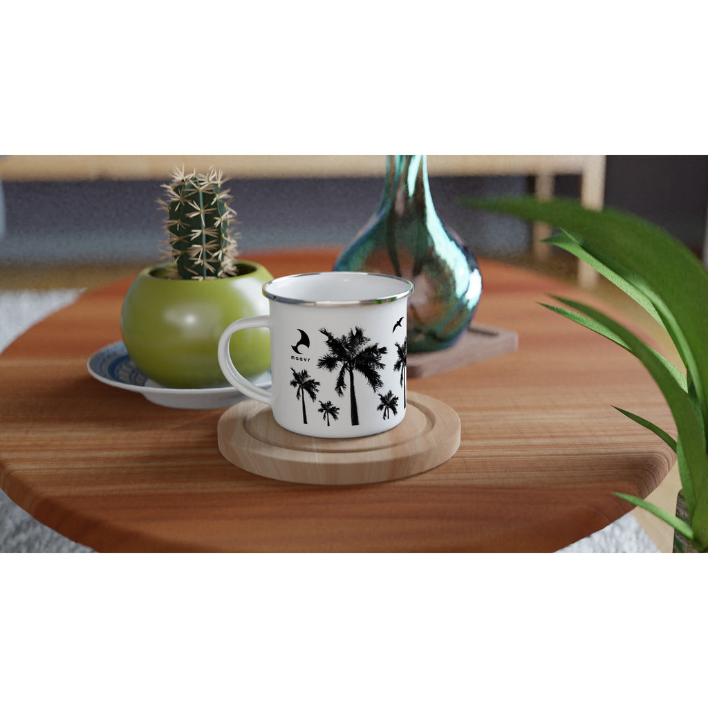 Weiße Emaille-Tasse mit silbernem Rand schwarzen Palmen-Motiven, maavr Logo auf Holztisch arrangiert mit Kaktus und Vase