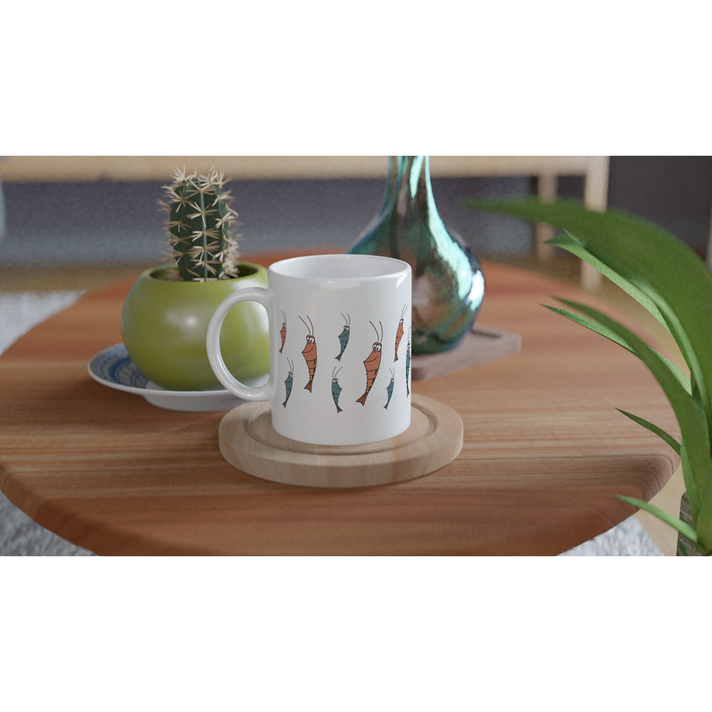 Keramiktasse mit Garnelen Motiv auf Tisch neben Pflanze im Wohnraum