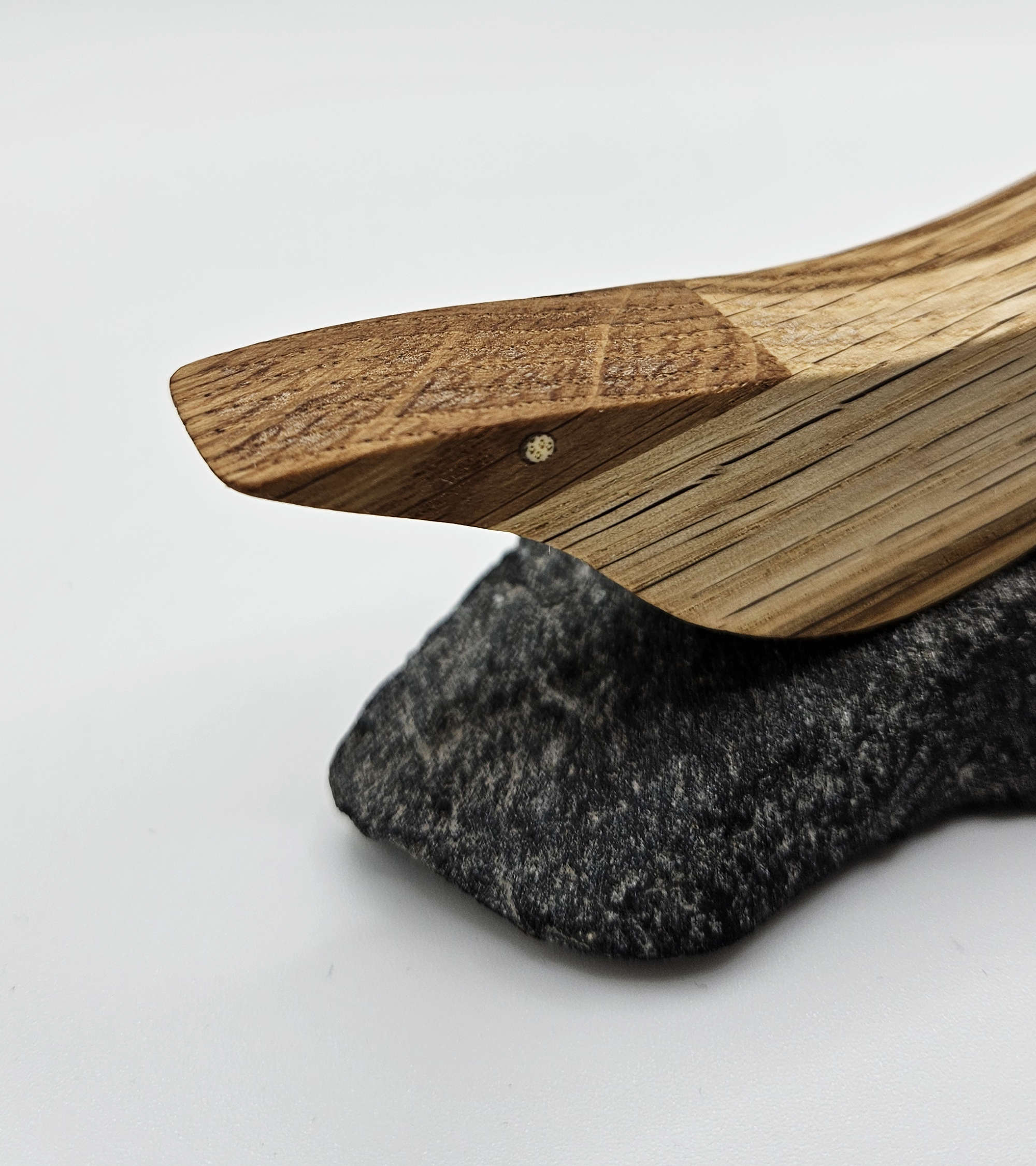 Detailansicht eines Holzvogels mit kleiner, heller Intarsie 