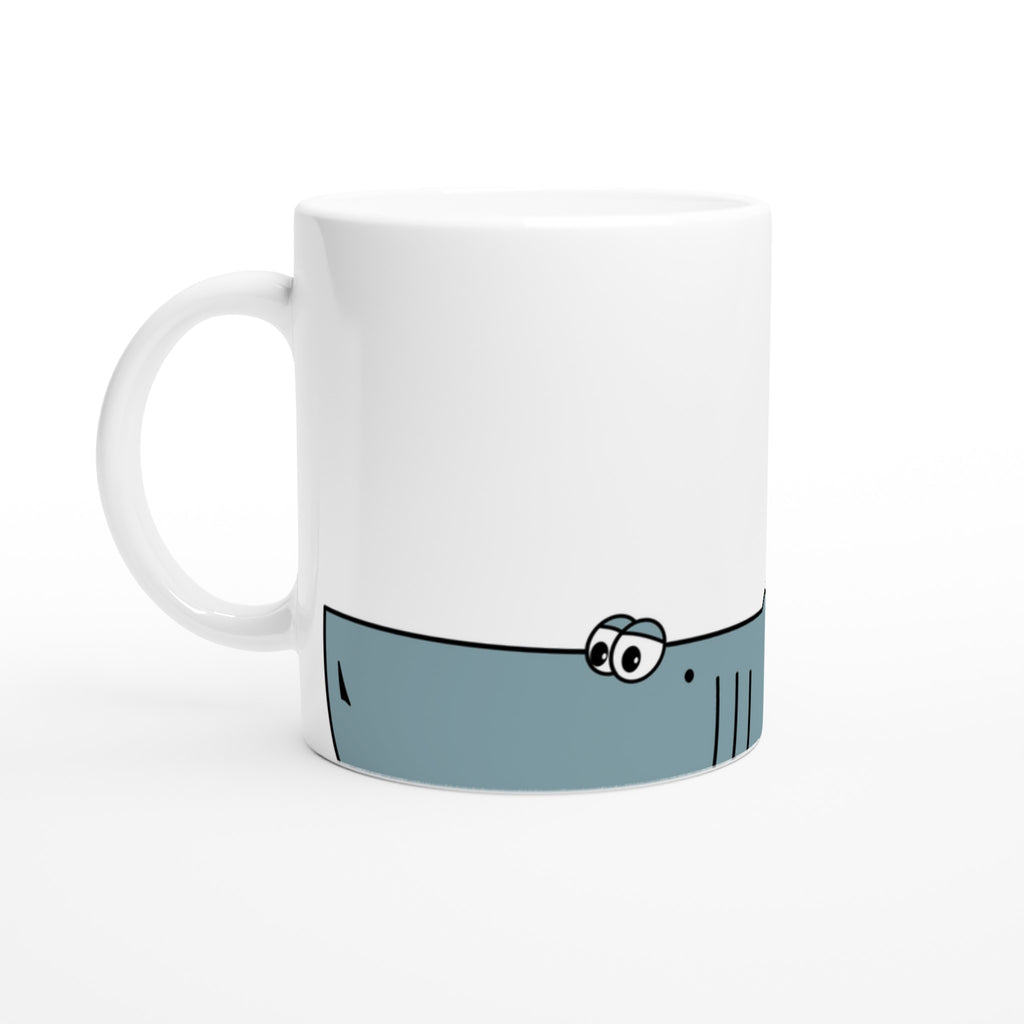 Weiße Keramiktasse mit blauem Cartoon-Hai-Motiv im unteren Drittel der Tasse 