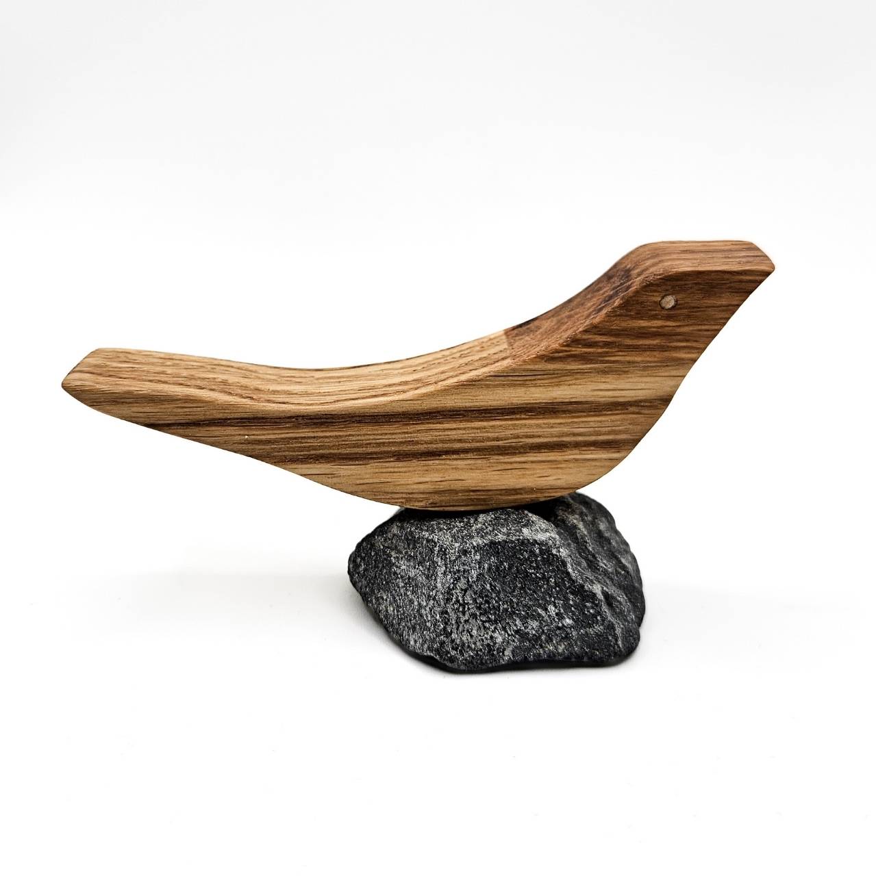 Handgefertigter Holzvogel aus Eiche auf Naturstein als minimalistische maritime Dekoration