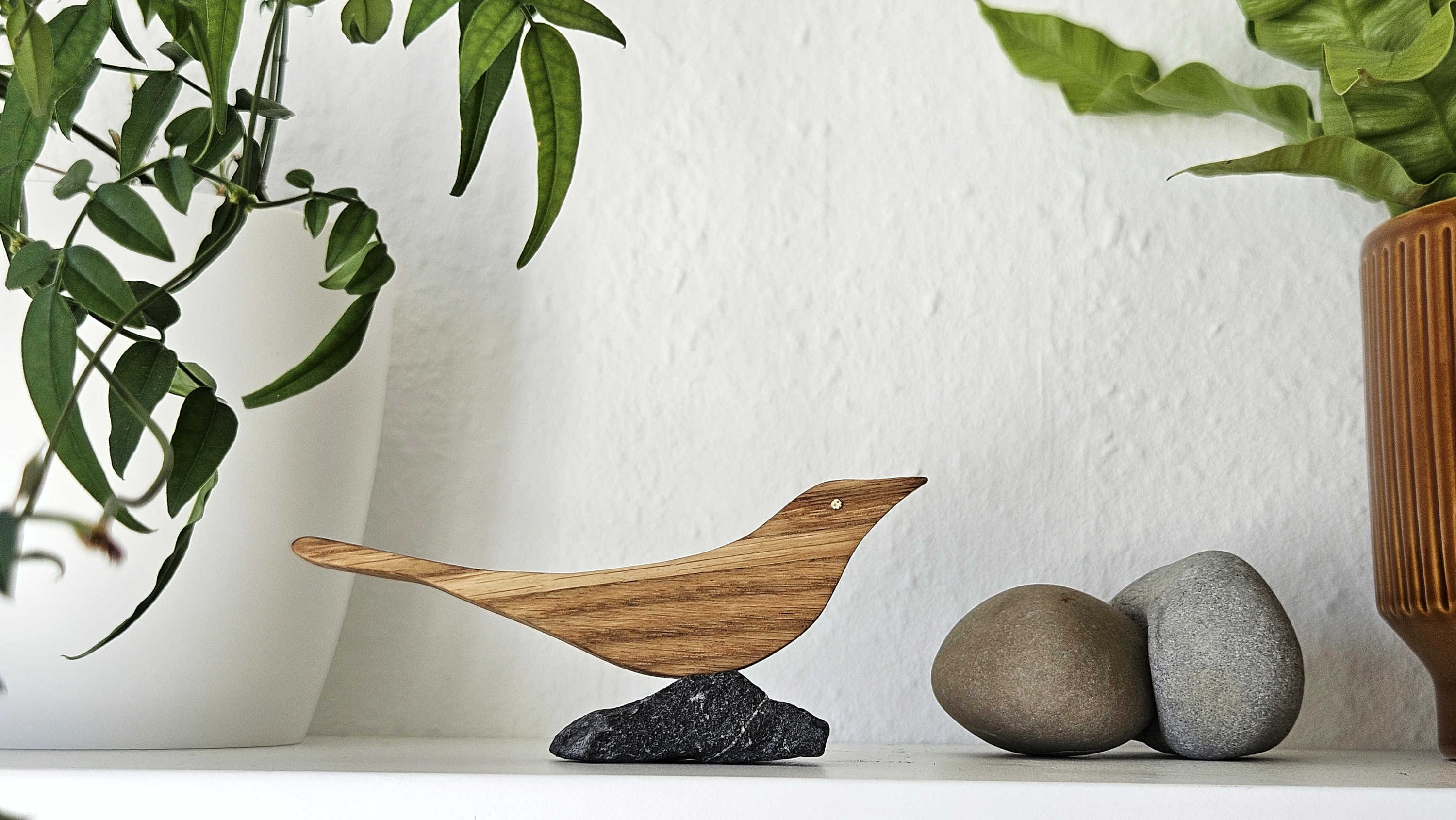 Dekorativer Holzvogel auf Stein in moderner Wohnraumdekoration