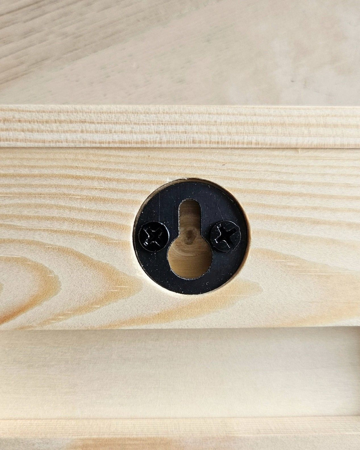 Rückseite des Wellenreliefs aus Holz mit schwarzer Schlüssellochaufhängung