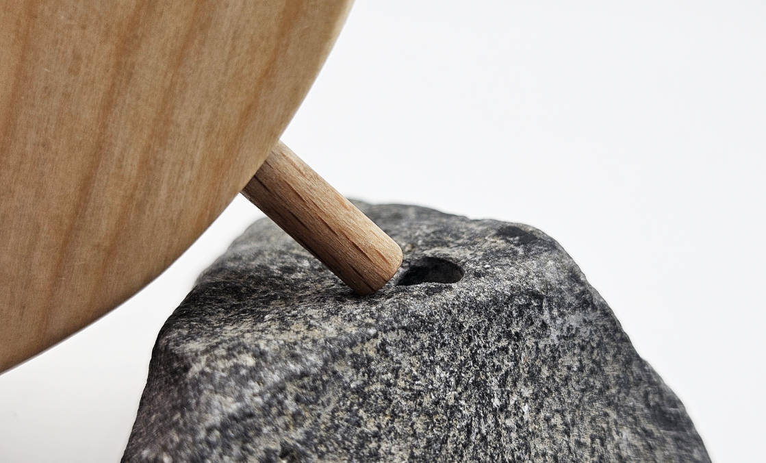 Detail der Steckverbindung zwischen Holzvogel aus Eiche und gebohrtem Naturstein