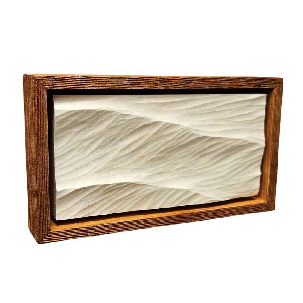 Swell Waves – handgeschnitztes Wellenrelief aus hellem Holz in einem dunkelbraunen Holzrahmen, schräg von vorne fotografiert.