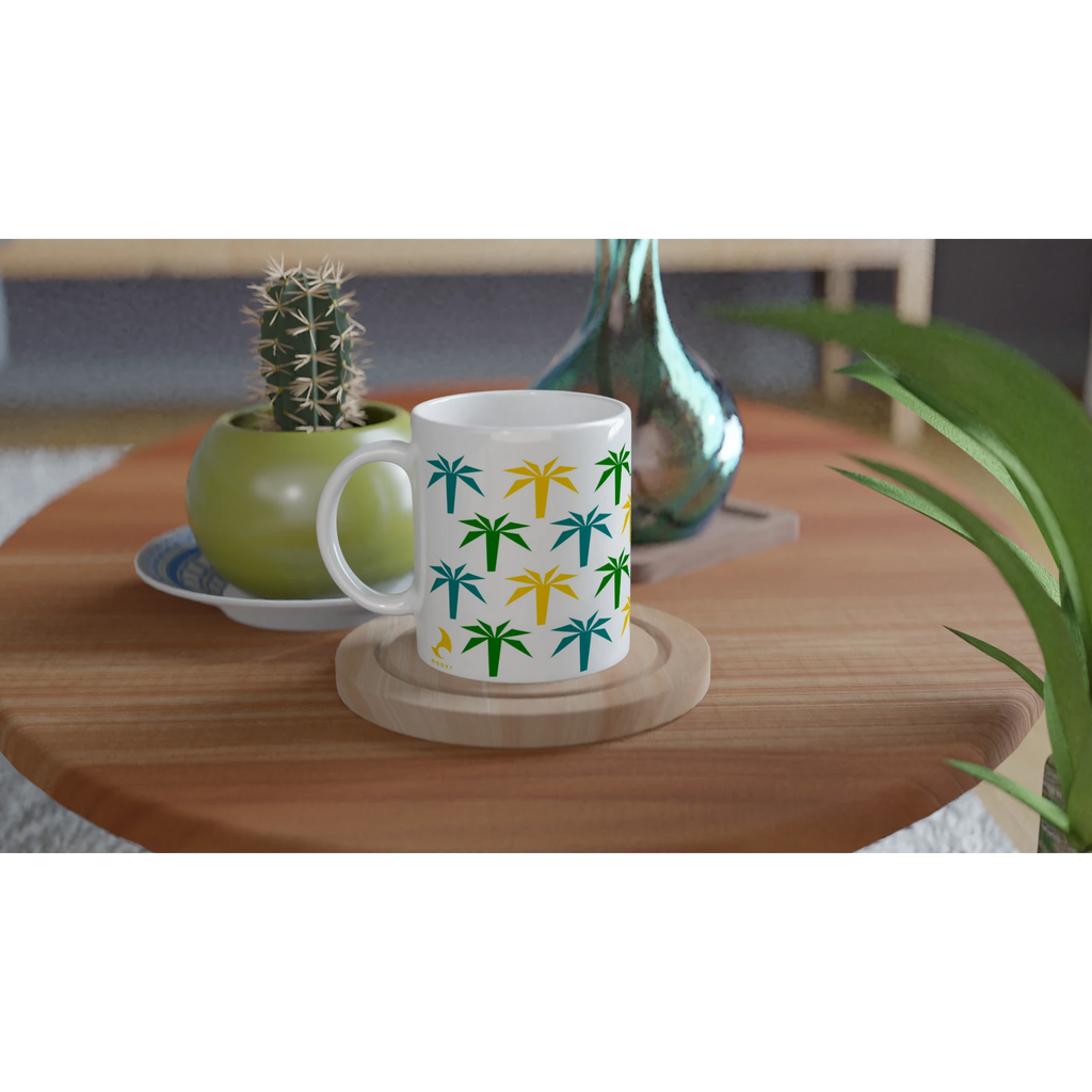 Keramiktasse mit buntem Palmenmotiv auf einem Holztisch neben Zimmerpflanzen
