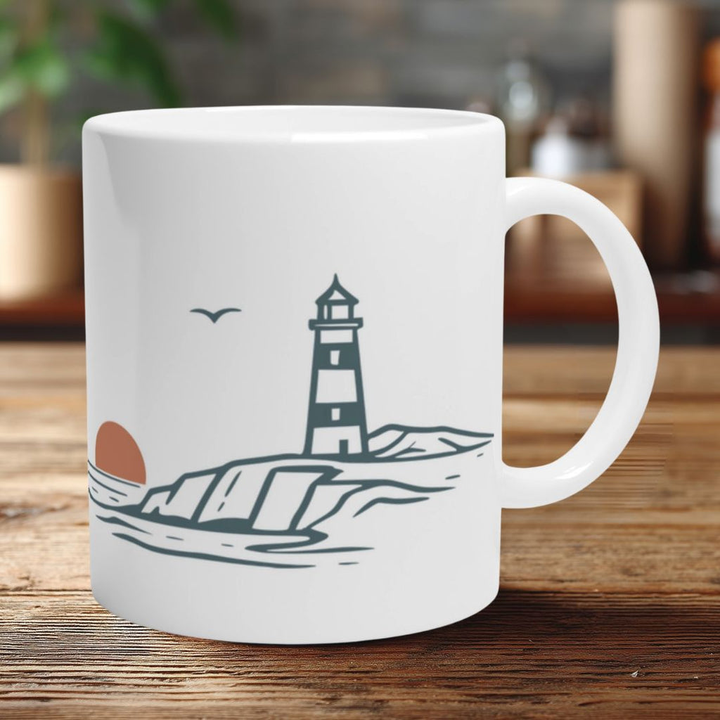Weiße Keramiktasse mit minimalistischem Leuchtturm-Motiv an einer Küste mit Sonne und Möwe  auf Holztisch