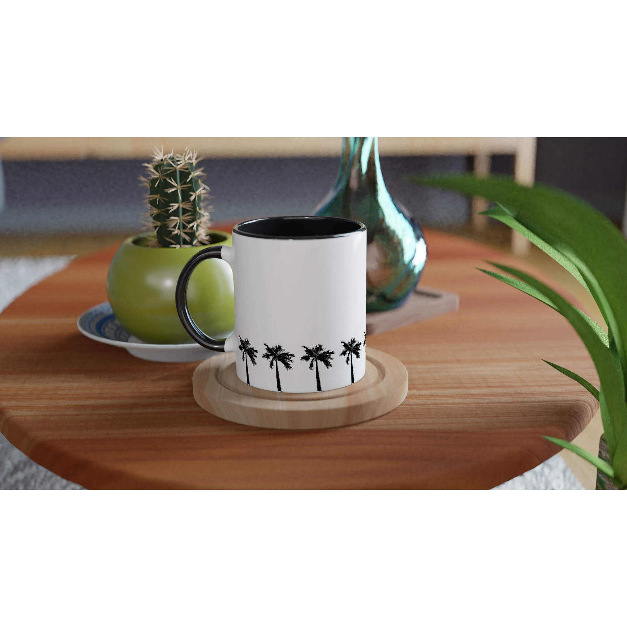 Keramiktasse mit umlaufender Palmenreihe, schwarzer Innenfläche und schwarzem Henkel auf Holztisch