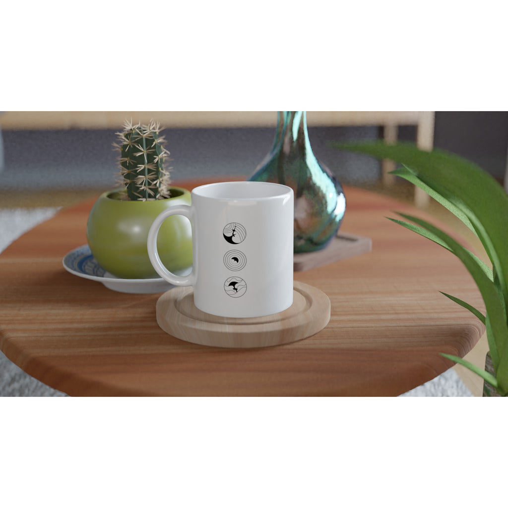 Weiße Keramiktasse mit schwarzen Wingfoil-Icons auf Holztisch