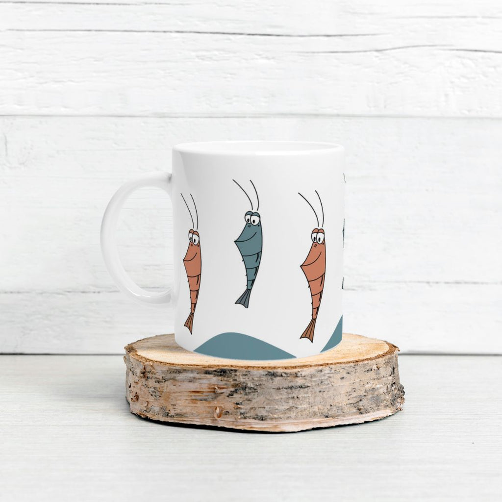 Tasse mit  Garnelen-Motiv auf Holzstück vor weißer Holzwand