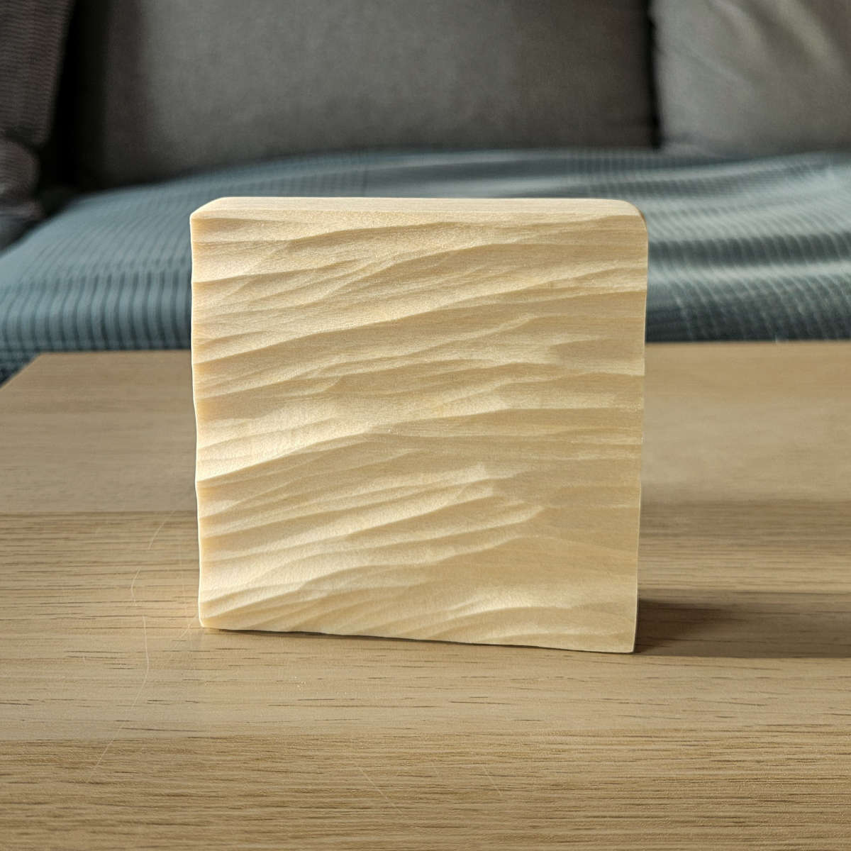 Freistehendes Wellenrelief aus Holz als handgeschnitzte maritime Dekoration auf einem Tisch