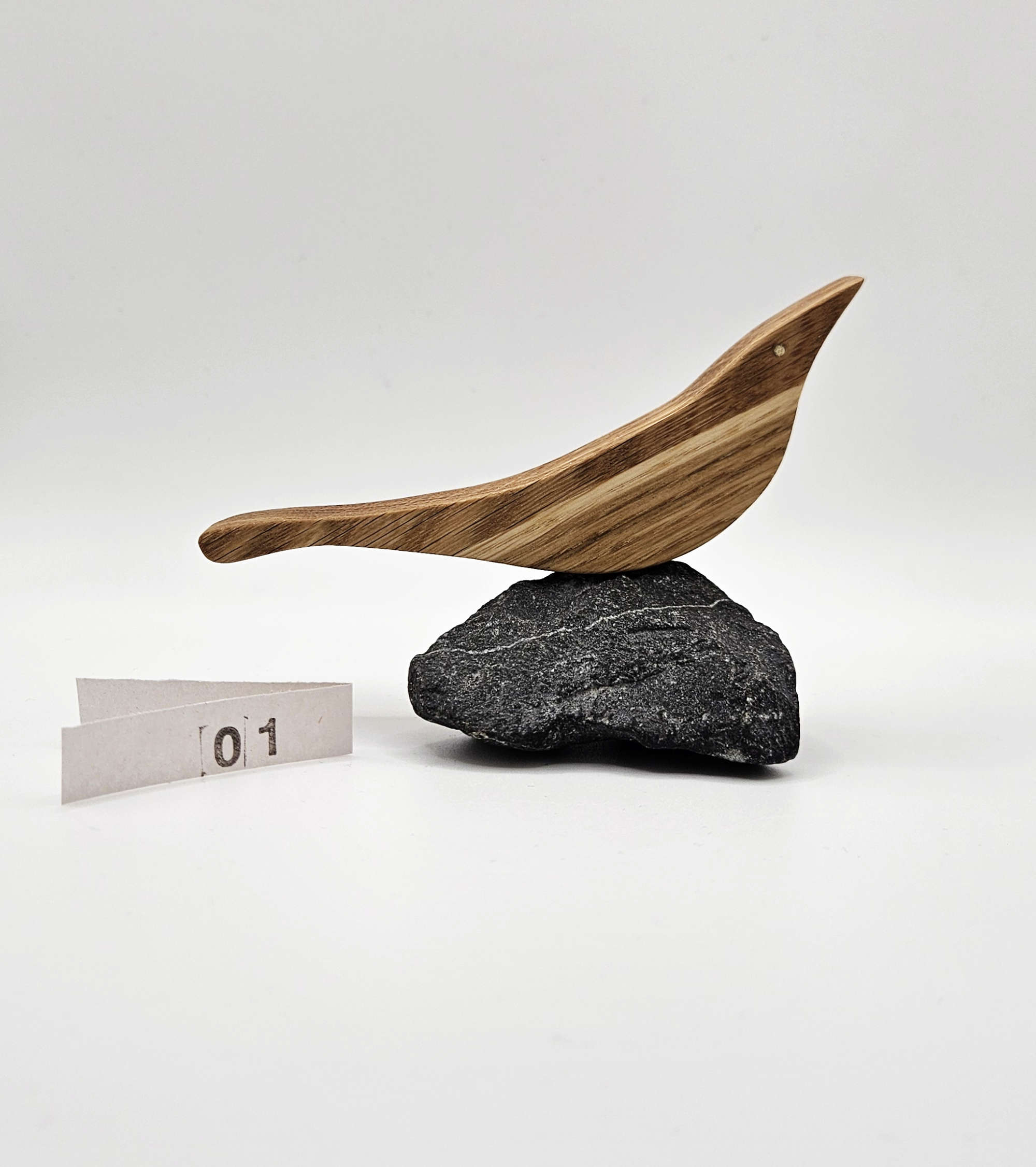 Holzvogel aus Eiche auf einem naturbelassenen Stein