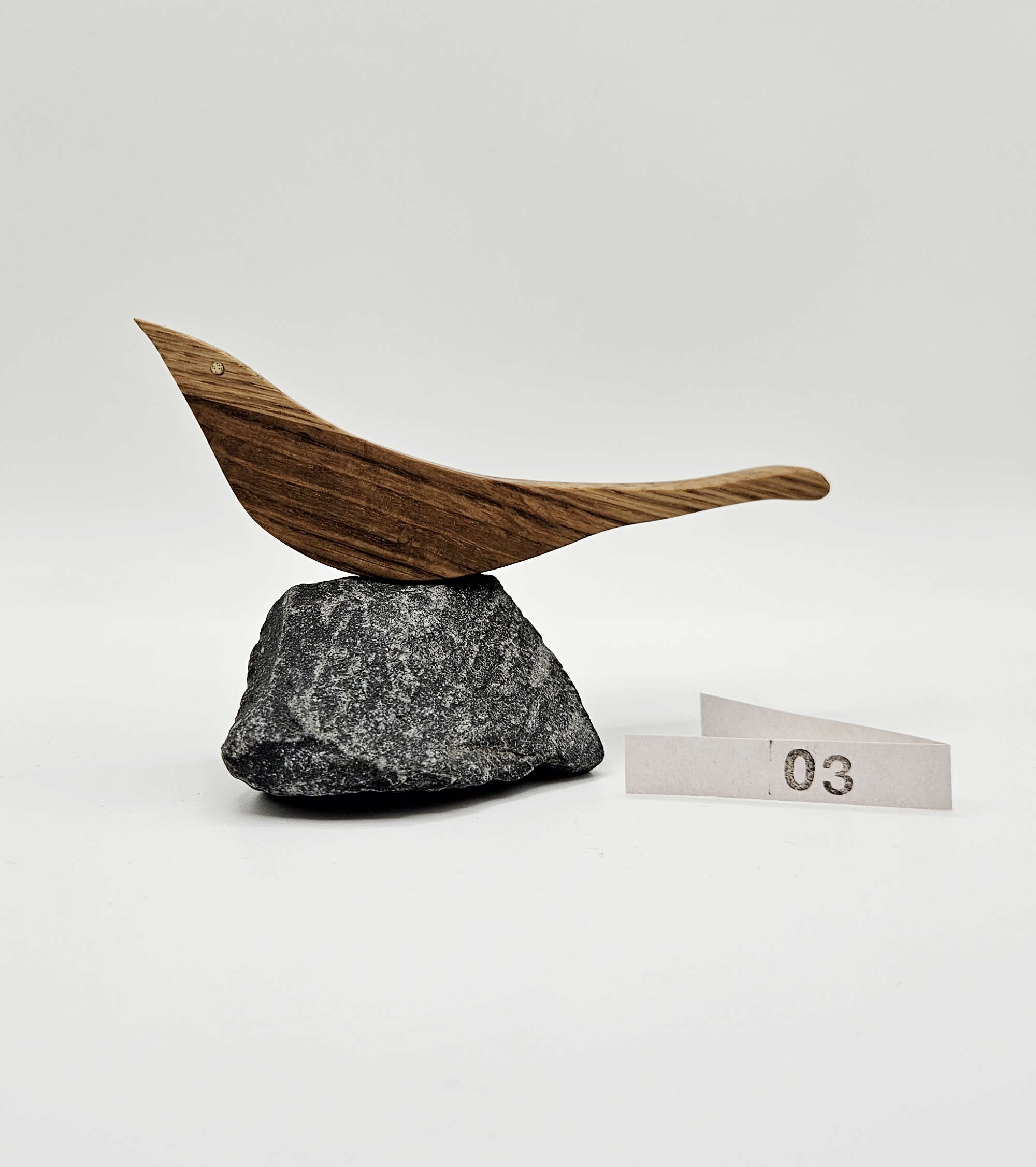 Holzvogel aus Eiche auf einem naturbelassenen Stein