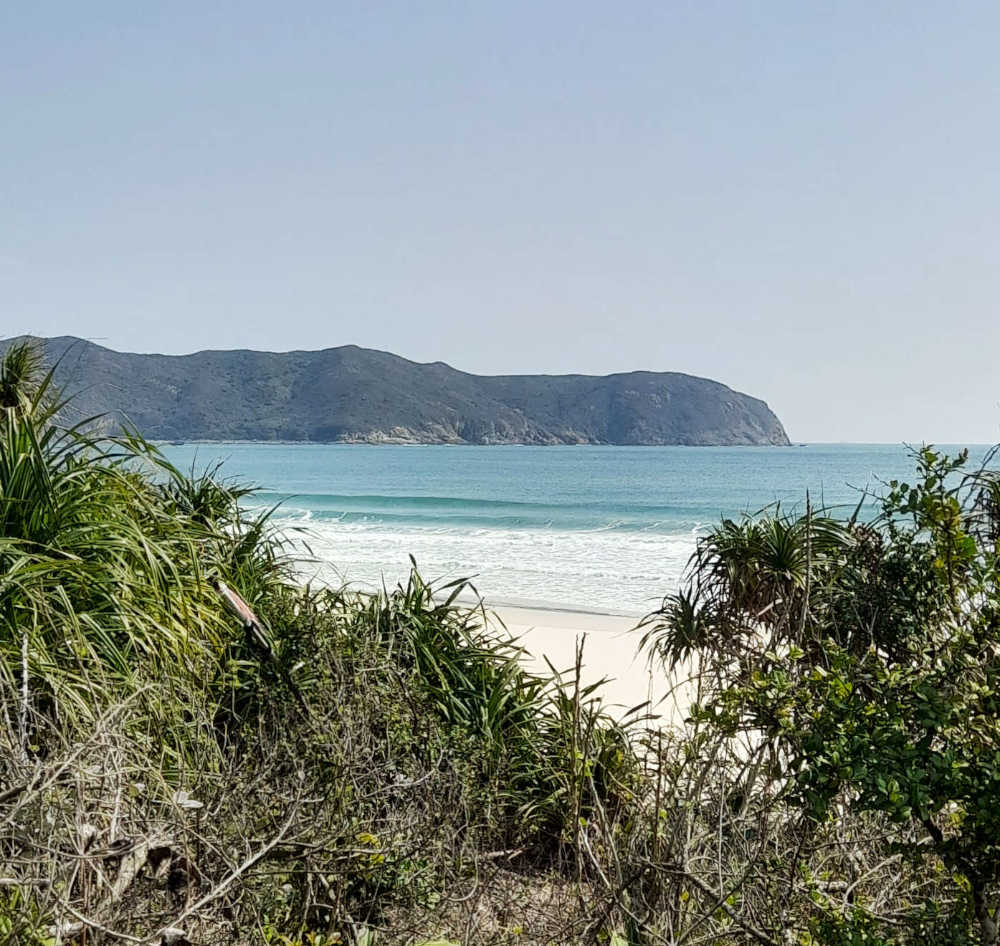 Strand mit Meer und Küstenlandschaft bei ruhigem Wetter
